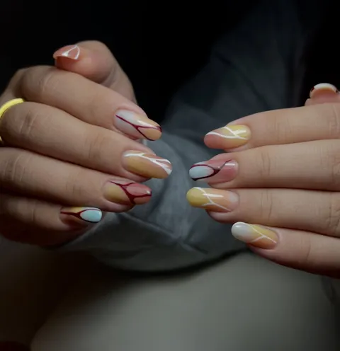 Short round gel nails in peach, yellow and pale blue with fine wine-red and white lines