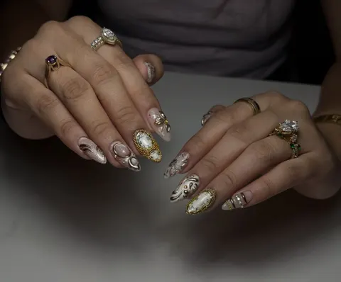 Long almond extensions with gold chrome swirls, beaded frames and clock-face art